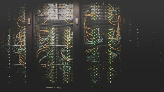 Server racks and network cables in a data centre, illustrative image